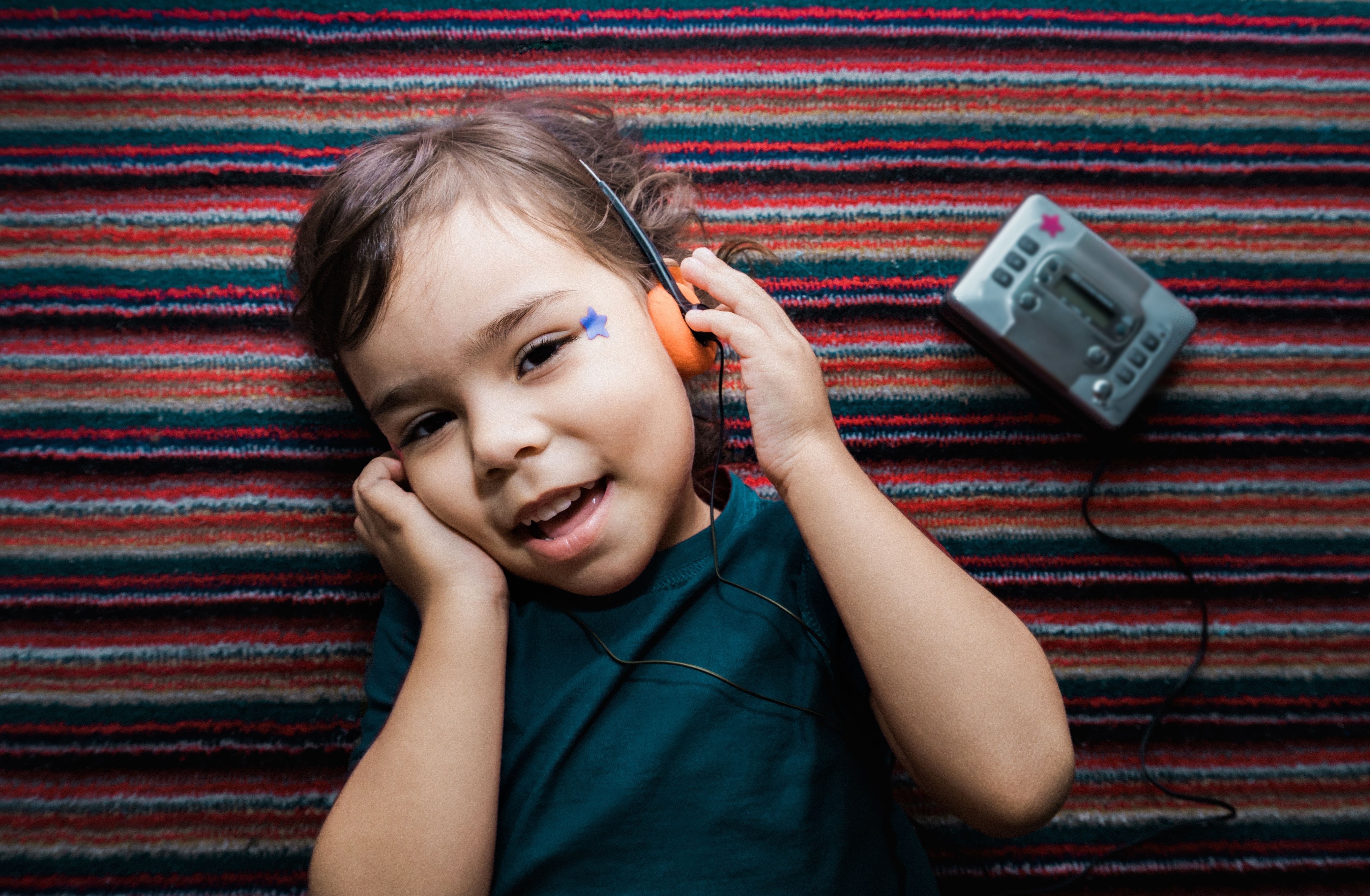 A girl lost in music on a vintage cassette player